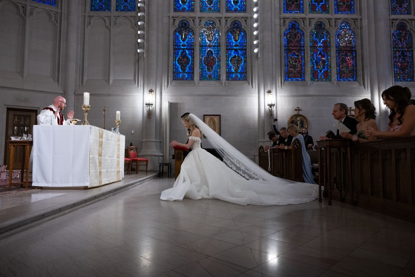 Bride approaching the altar, veil trailing, officiant waiting
