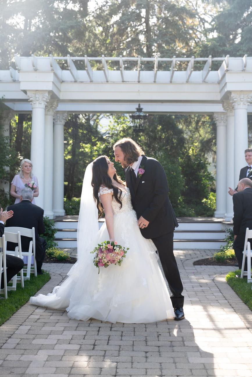 A couple's first kiss beneath a garden pergola