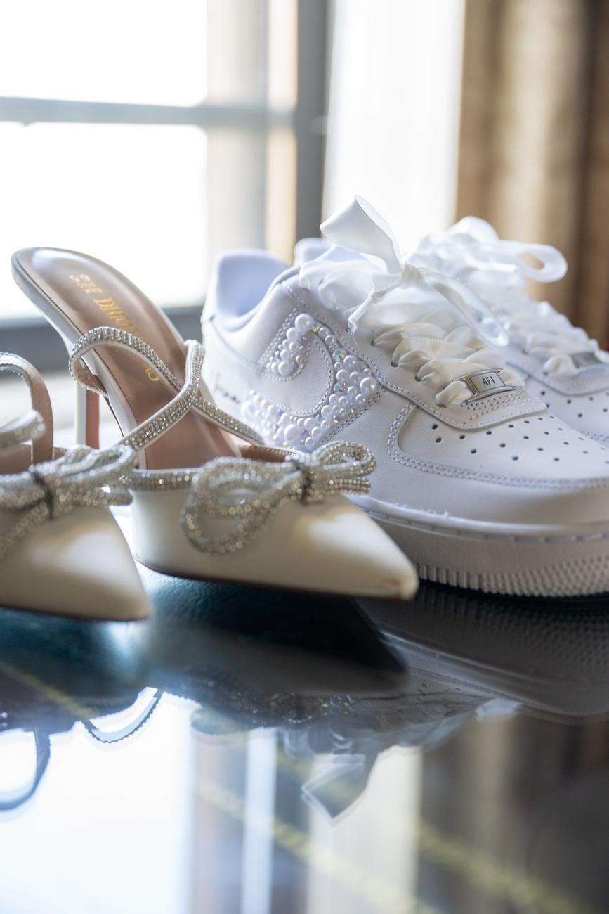Bridal shoes and personalized sneakers arranged on a table