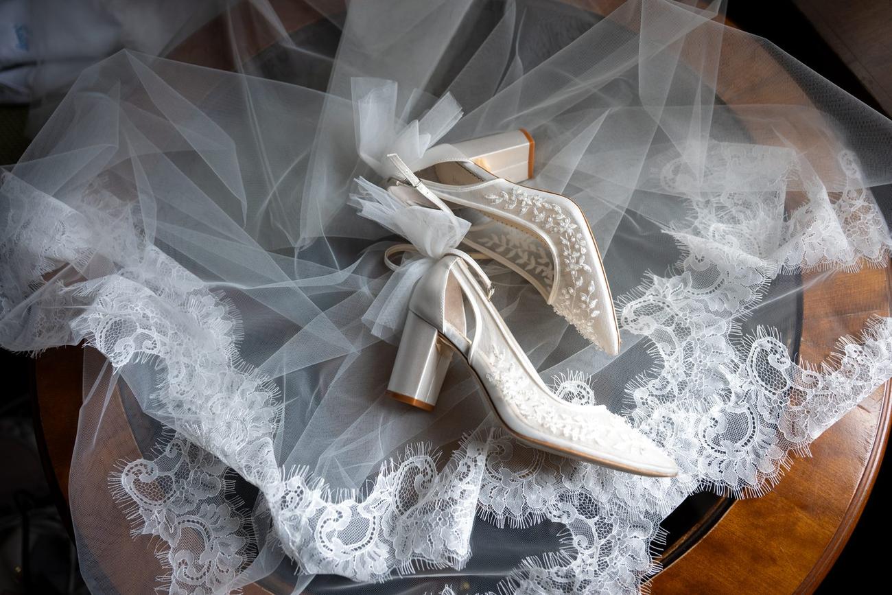 Veil and heels arranged on a wooden table