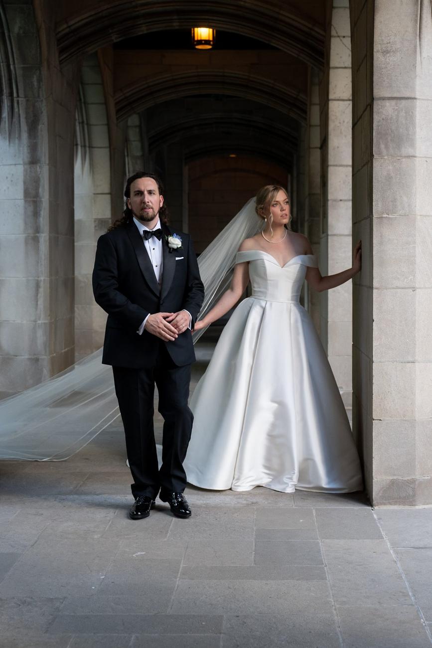 Bride's veil caught mid-motion in a stone colonnade