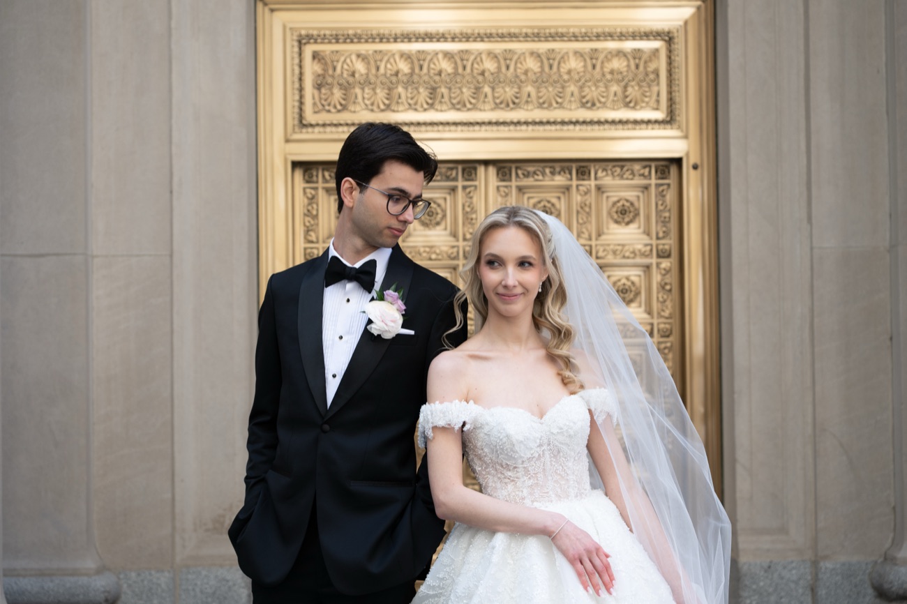 A couple posed before a grand gilded doorway