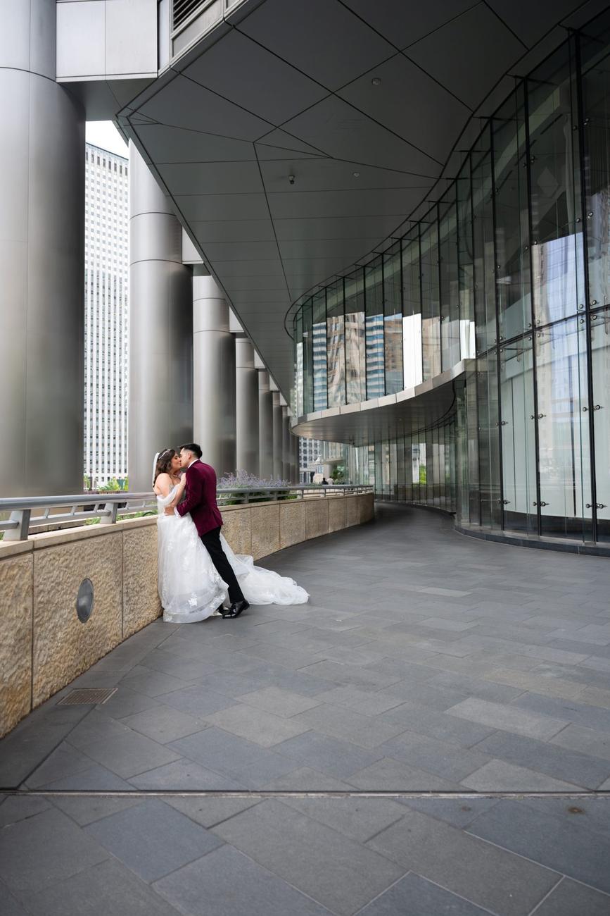A couple walking a curved modern glass-and-column walkway