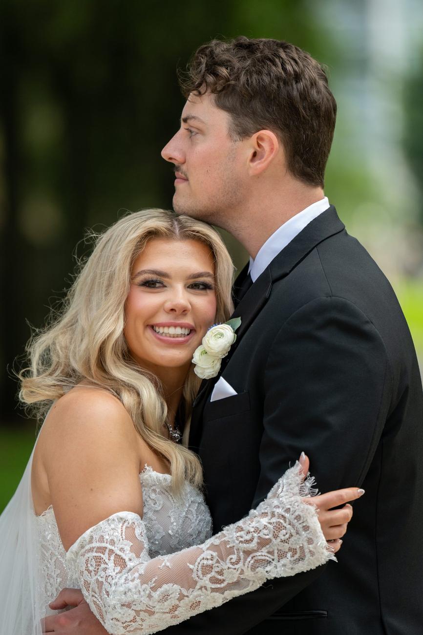 A close, quiet moment between a bride and groom outdoors