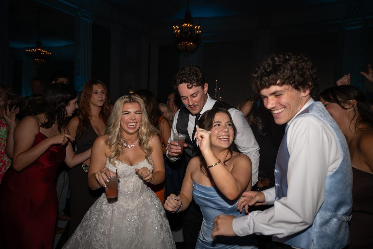 Guests dancing beneath chandeliers at a lively reception