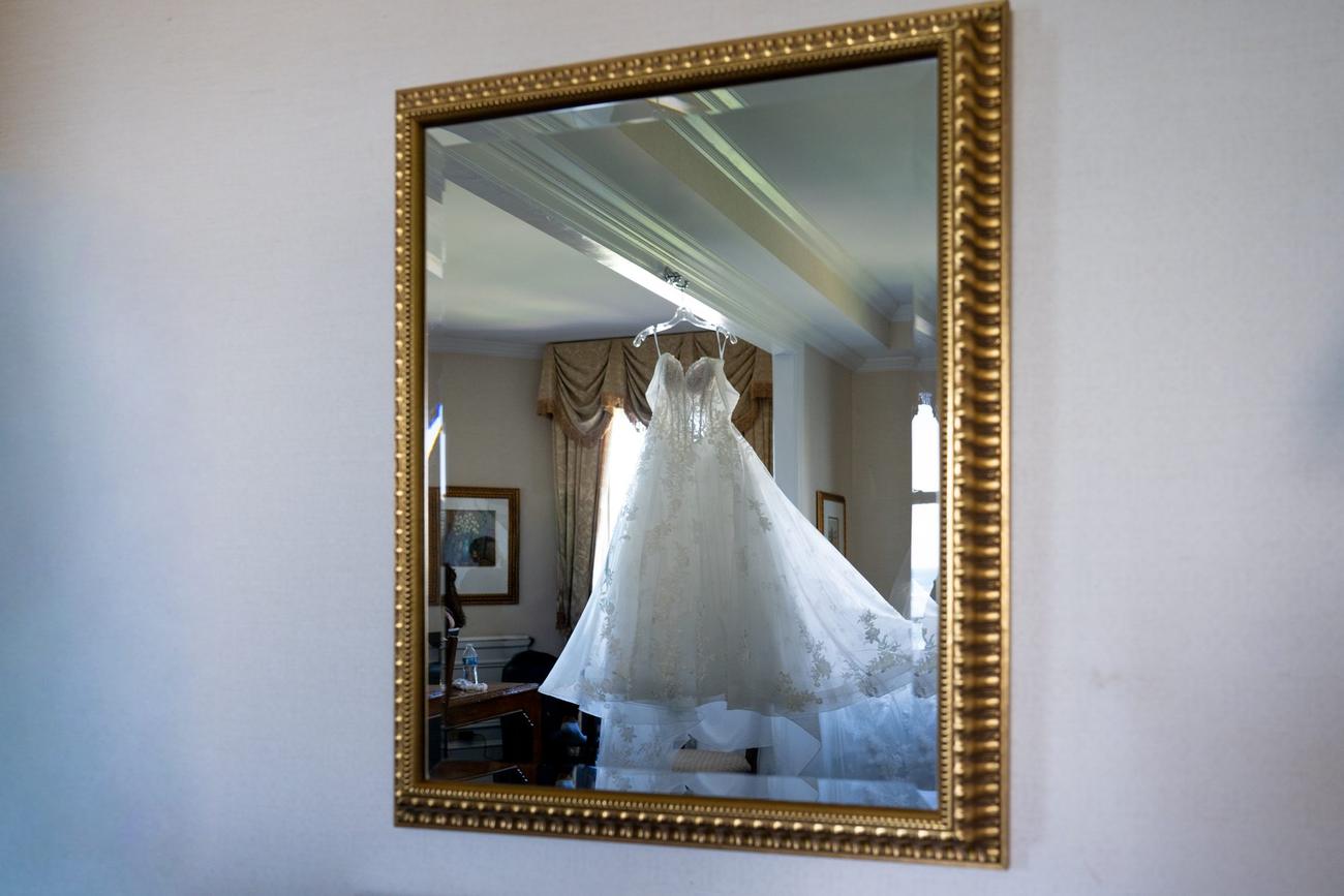 Wedding gown reflected in a gold-framed mirror