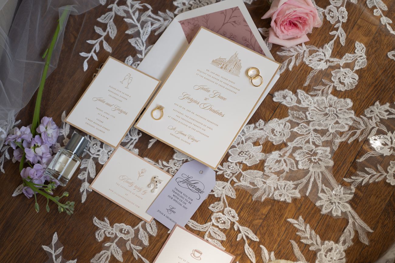 Wedding invitation suite arranged on lace with fresh flowers
