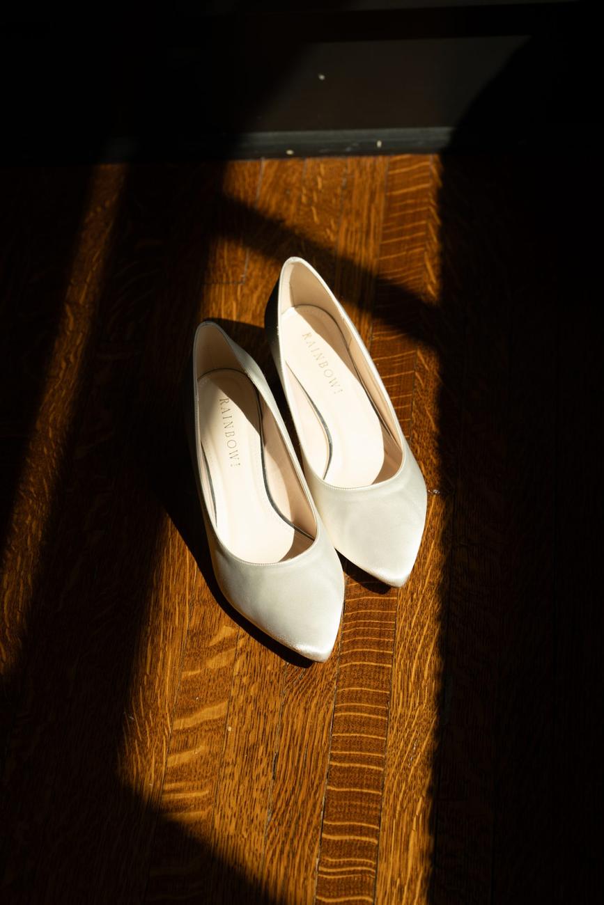 Bridal shoes resting on a sunlit windowsill