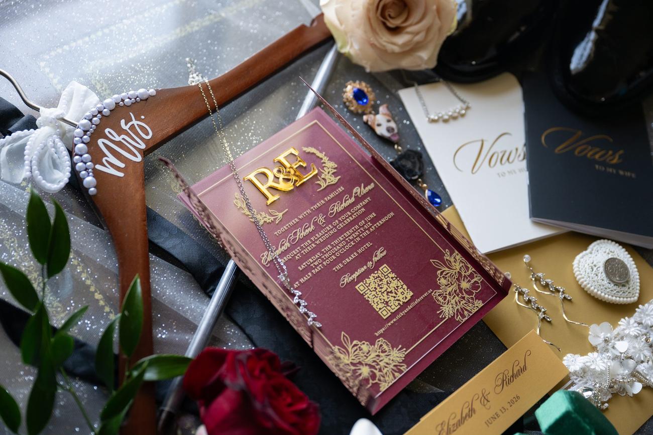 Wedding invitation suite and jewelry arranged as a flat lay