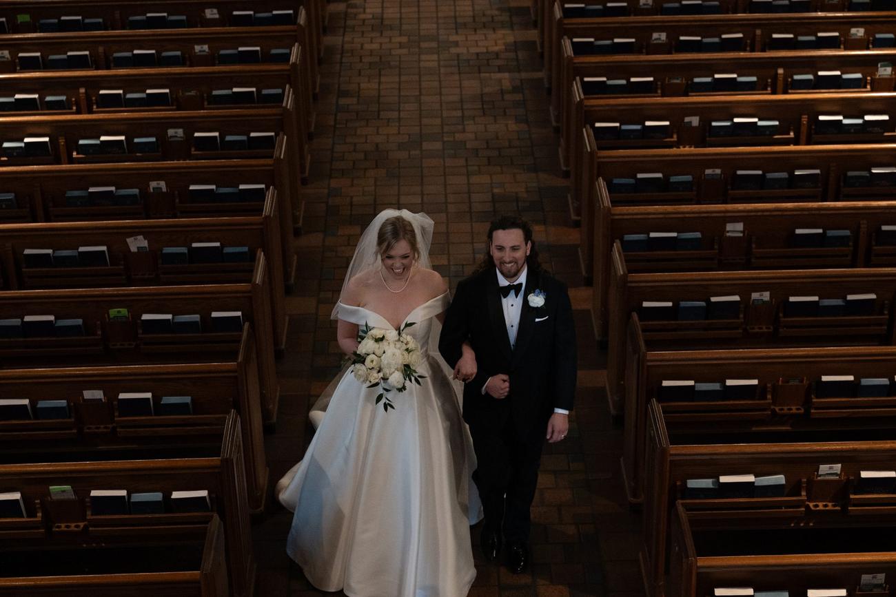 Bride and groom recessing down the aisle of a grand cathedral