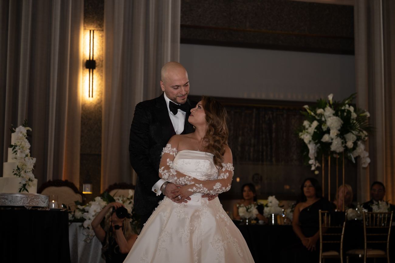 An older family member embracing the bride at the reception