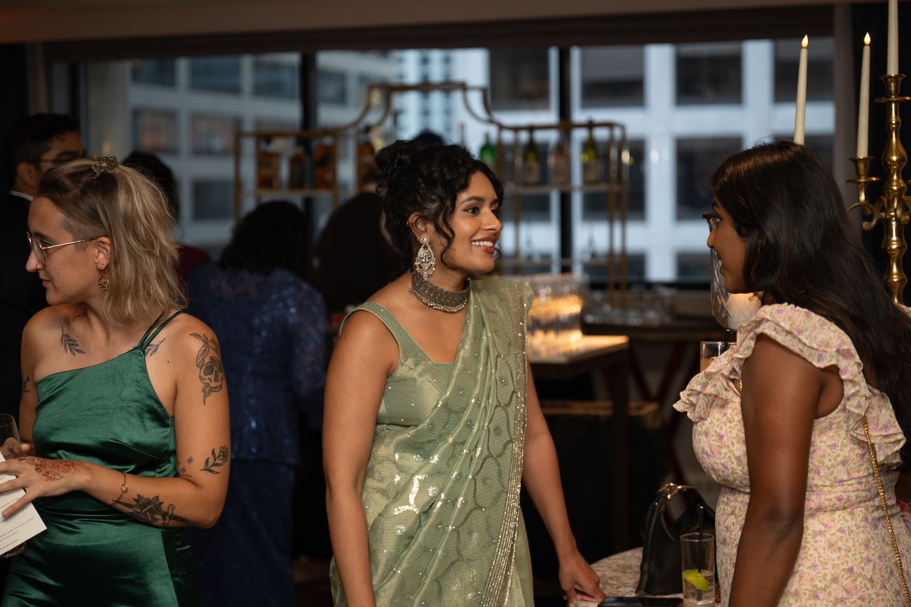 Guests in colorful formalwear mingling and laughing at the reception
