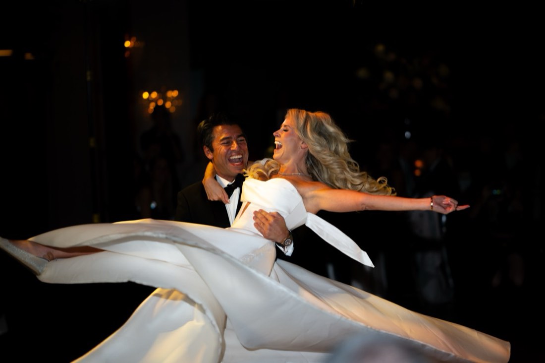 A couple laughing mid-swirl on the dance floor