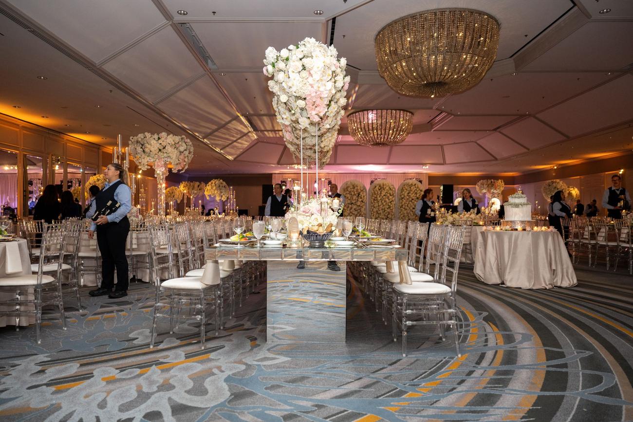 Grand ballroom reception with chandeliers and florals